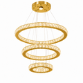 Lustre cristal LED à trois anneaux dorés suspendu dans un salon moderne